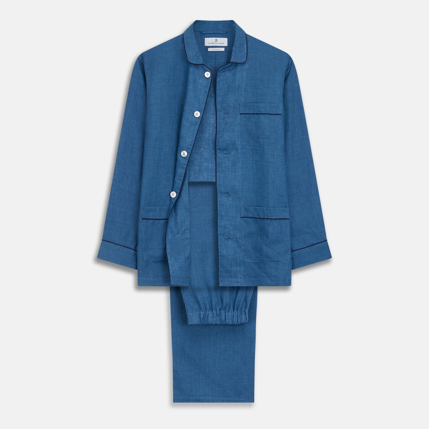 View 2 of product A person stands barefoot against a plain background, wearing the Teal Linen Modern Pyjama Set from Turnbull & Asser.