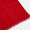 View 2 of product The Turnbull & Asser Red Cashmere Scarf features a soft texture, subtle frayed edges, and long ends. Loosely knotted against a plain light background, it’s an elegant accessory that adds a touch of style to any outfit.