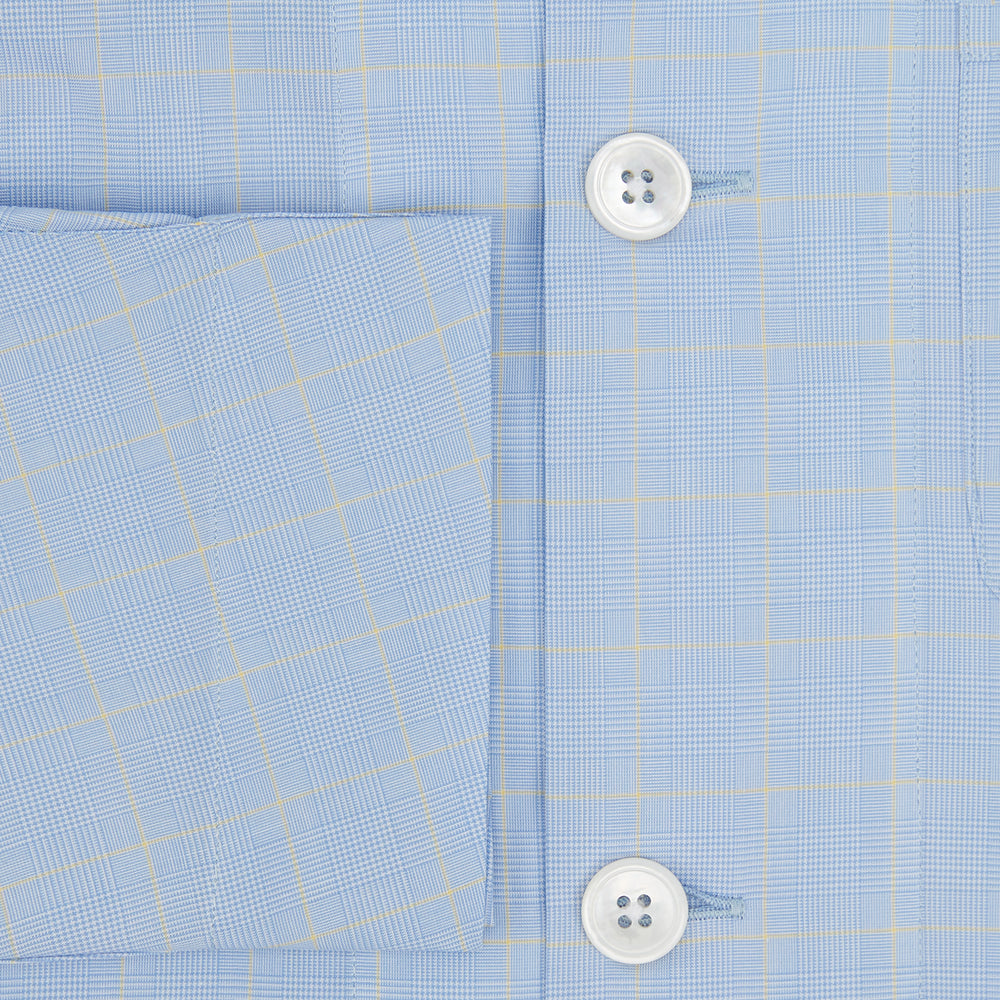 The Turnbull & Asser Blue Prince of Wales Check Pyjama Shirt features long sleeves, a notched collar, a left chest pocket, and a subtle check pattern, shown laid flat on a white background.