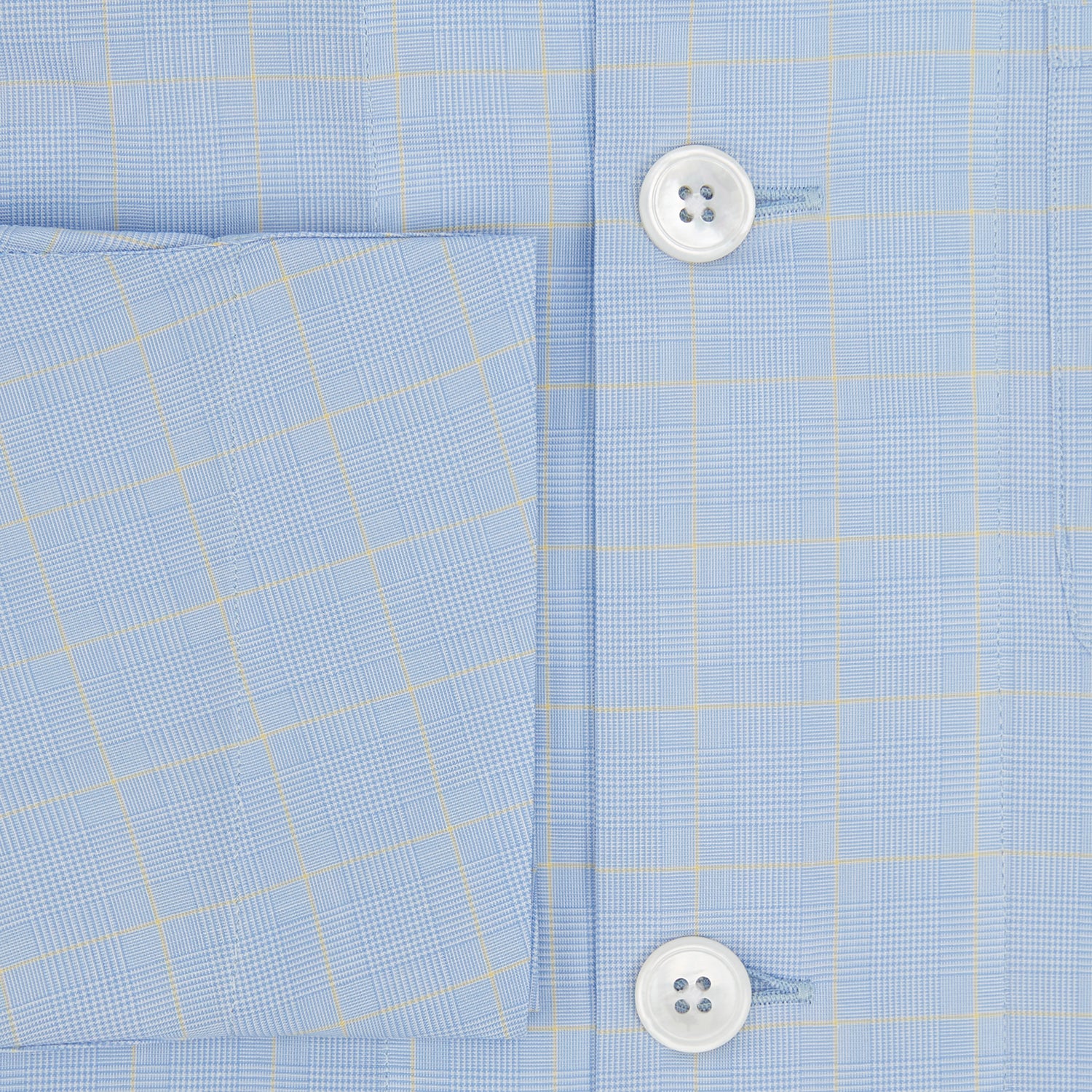 View 4 of product The Turnbull & Asser Blue Prince of Wales Check Pyjama Shirt features long sleeves, a notched collar, a left chest pocket, and a subtle check pattern, shown laid flat on a white background.