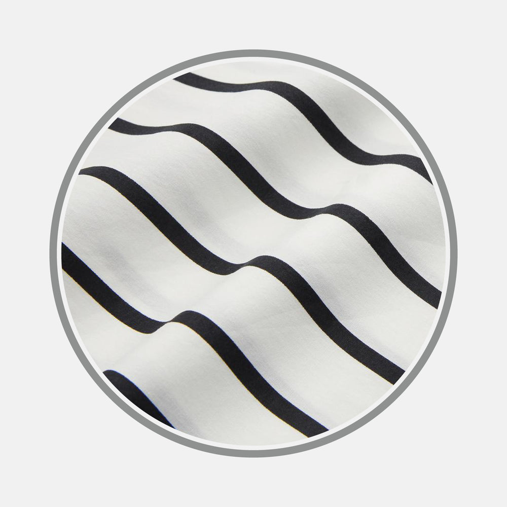 A close-up of Turnbull & Asser's Black & White Wide Stripe Cotton Fabric, featuring evenly spaced wavy black stripes on white, displayed in a circular frame against a plain background.