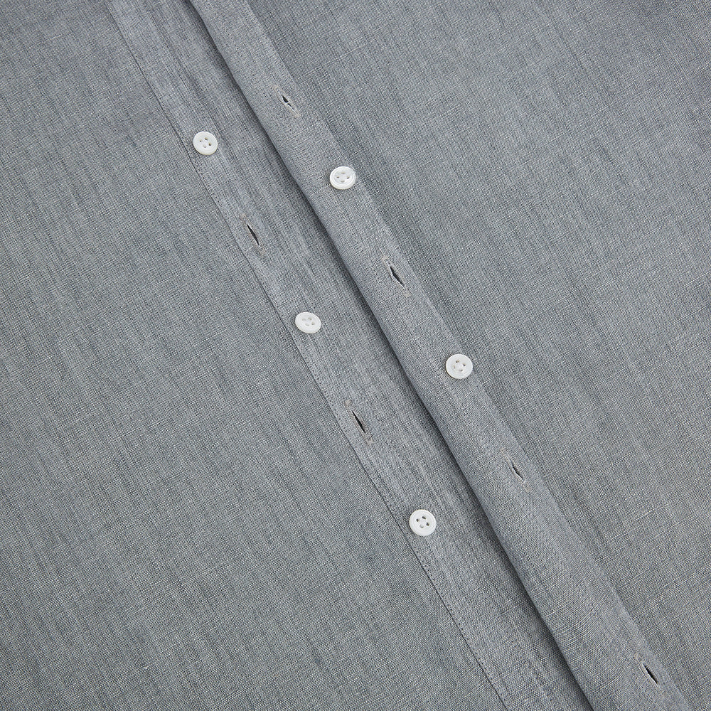The Grey Linen Westminster Shirt by Turnbull & Asser is a long-sleeve, light gray button-up with a formal collar and white buttons, highlighting British craftsmanship and laid flat on a white background.