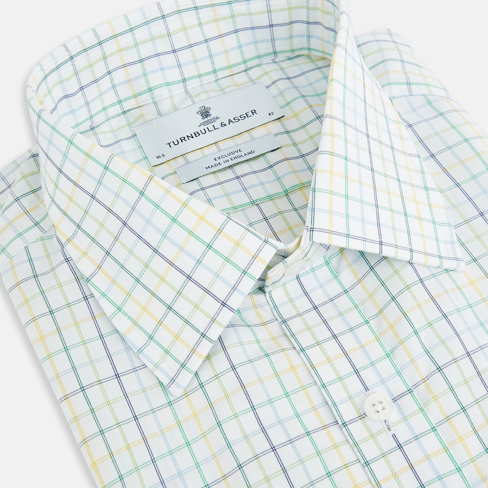 The Turnbull & Asser Multi Tone Double Grid Check Mayfair Shirt is a long-sleeve, button-up with a classic collar, showcasing pure cotton light blue, green, and yellow grid checks on white, neatly displayed flat against a white surface.