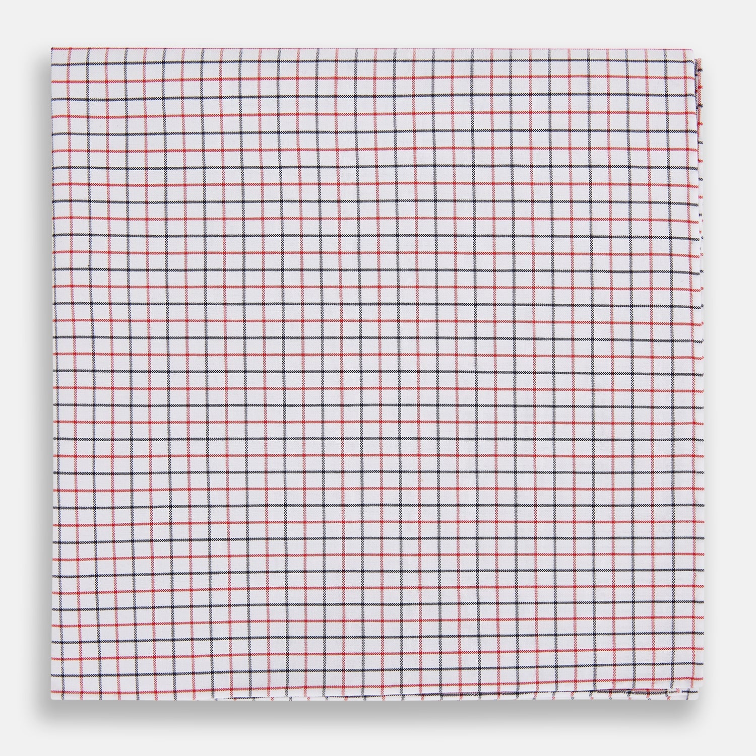 View 1 of product Turnbull & Asser’s Hand Rolled Red and Navy Graph Check Handkerchief—a white cotton accessory with red and navy grid lines, neatly folded for a touch of refined elegance.
