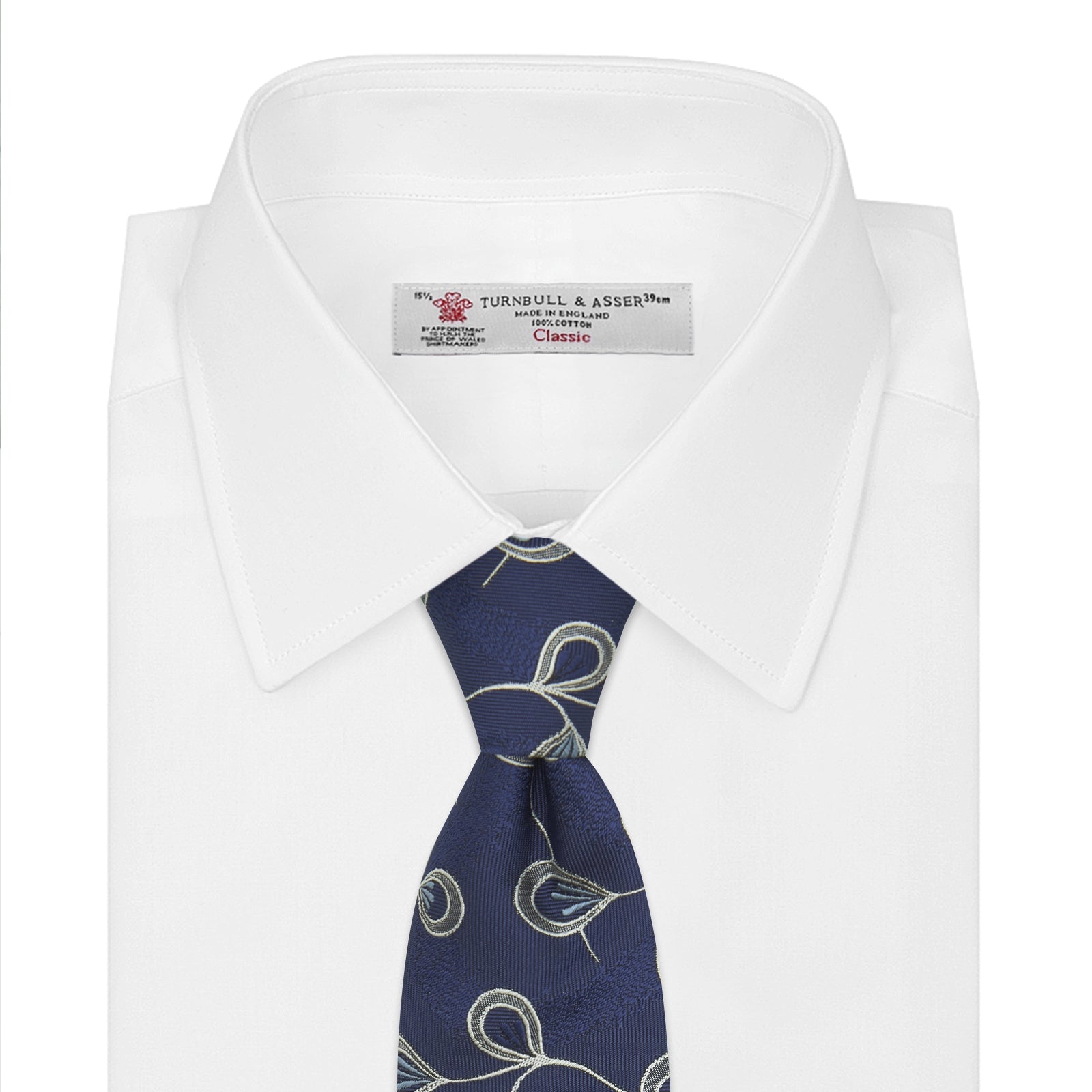View 2 of product The Turnbull & Asser Navy Jacquard Silk Floral Tie features white and light blue abstract leaf designs, exemplifying fine British craftsmanship. Shown rolled up against a white background.