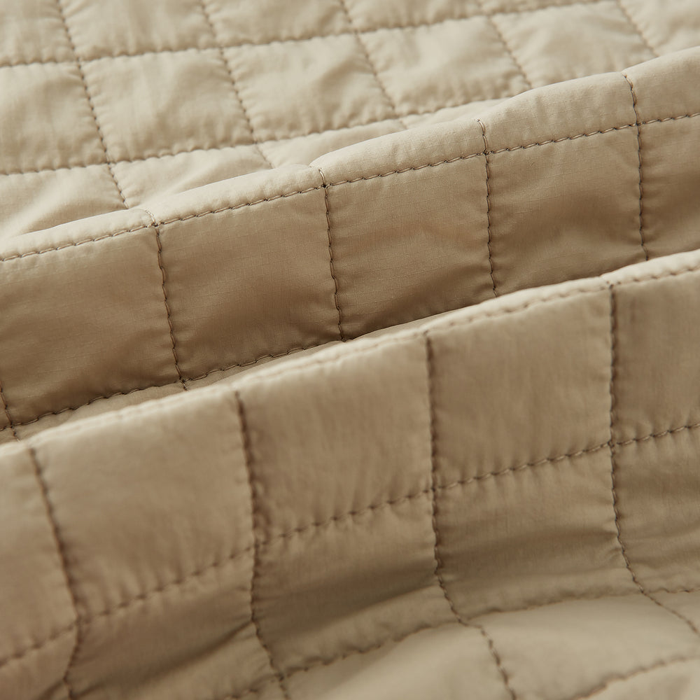 The Turnbull & Asser Sand Double-Breasted Quilted Gilet features a sleeveless design, brown buttons, slanted chest pocket, and two zippered side pockets—perfect for modern layered dressing. Shown on a plain white background.