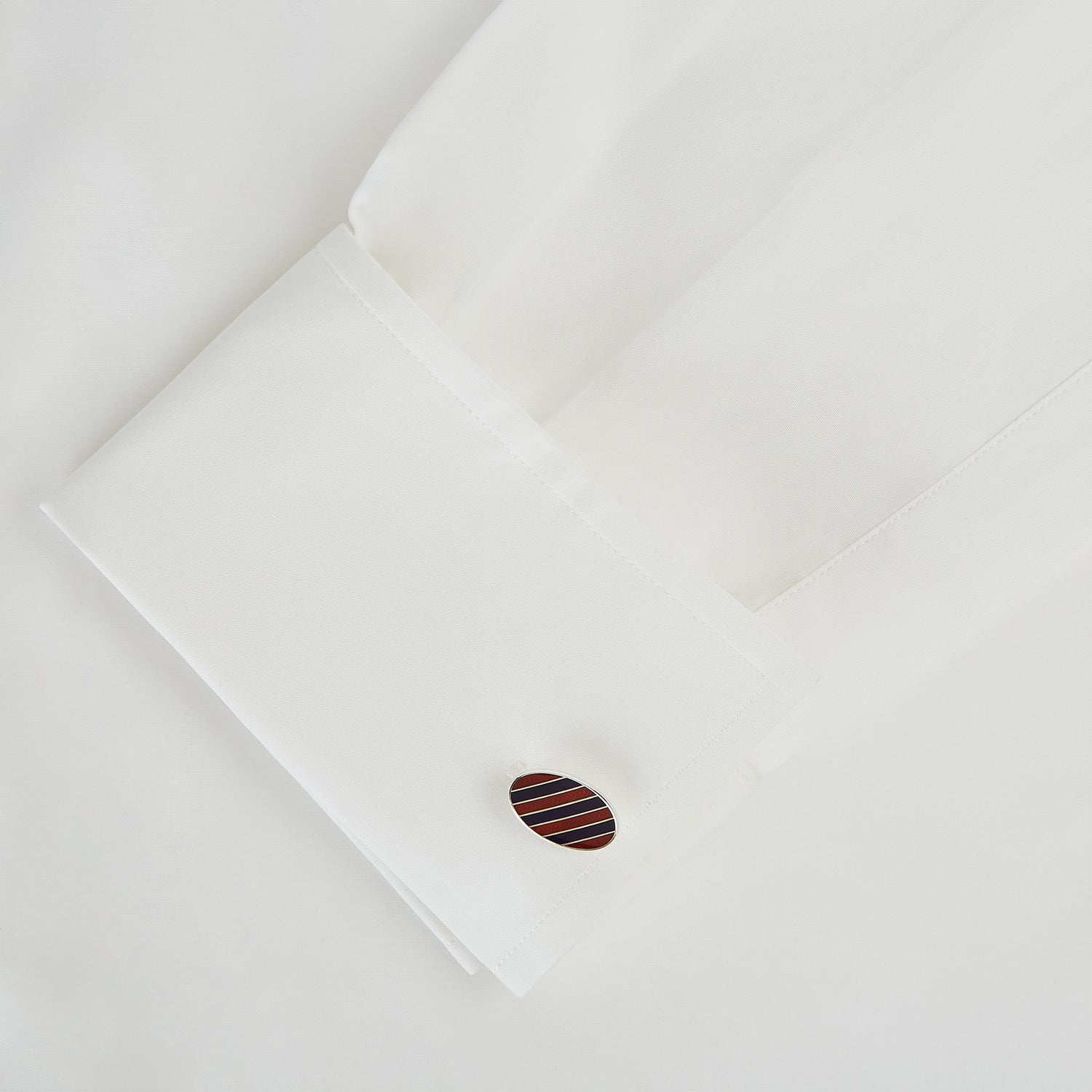 View 3 of product The Burgundy and Navy Striped Oval Enamel Cufflinks by Turnbull & Asser feature a silver oval design with bold stripes, adding a touch of masculine elegance to any ensemble.