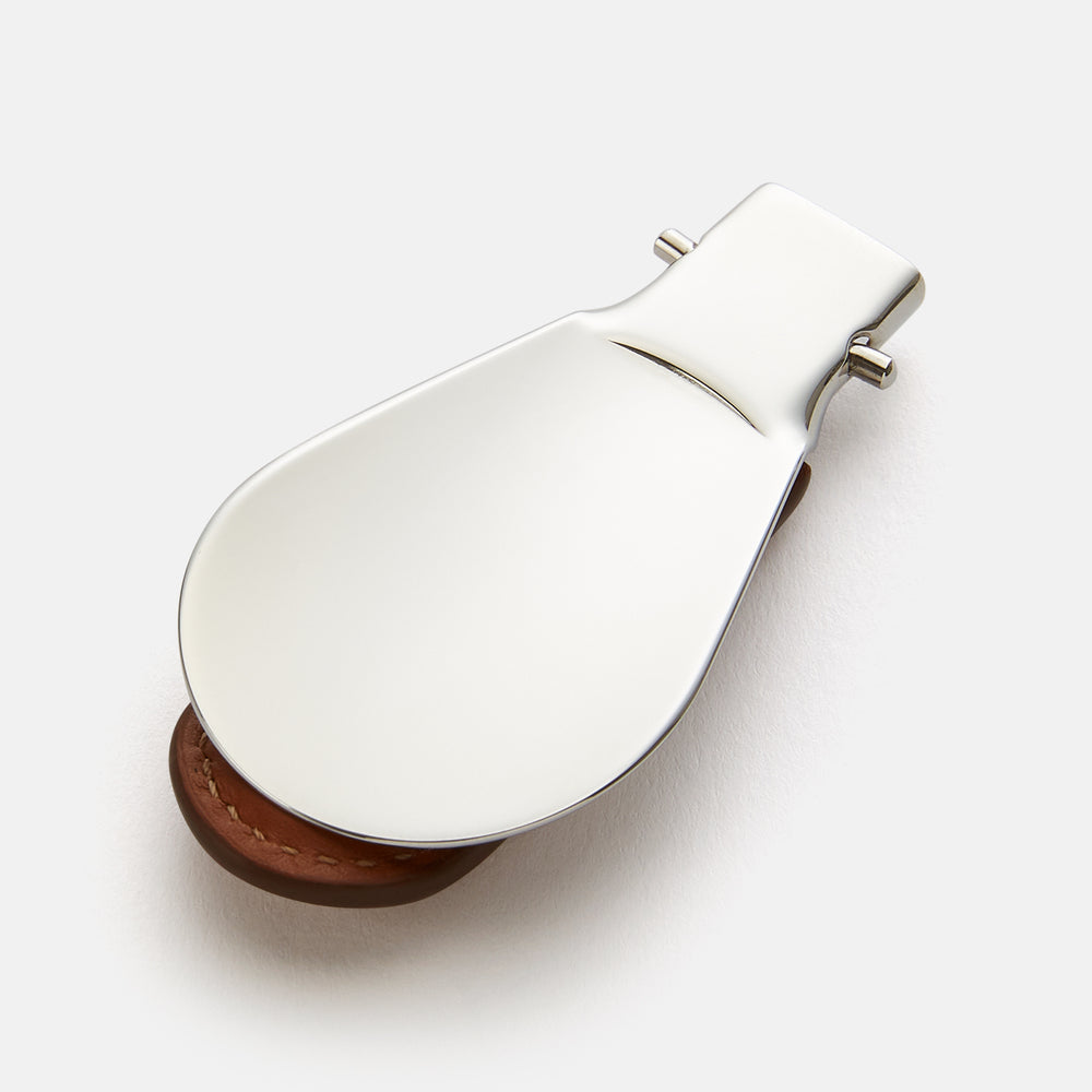 The Turnbull & Asser Camel Travel Shoe Horn features a wide, shiny silver blade and a brown Italian leather handle, displayed on a plain light background.