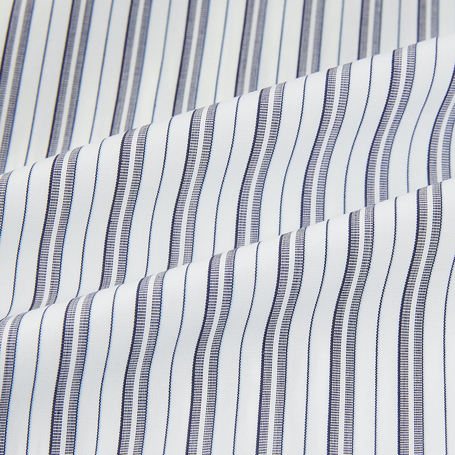 View 6 of product The Turnbull & Asser Navy Multi Stripe Mayfair Shirt, a pure cotton button-up with long sleeves and a collar, features thin vertical blue and white stripes and is displayed flat on a white background.