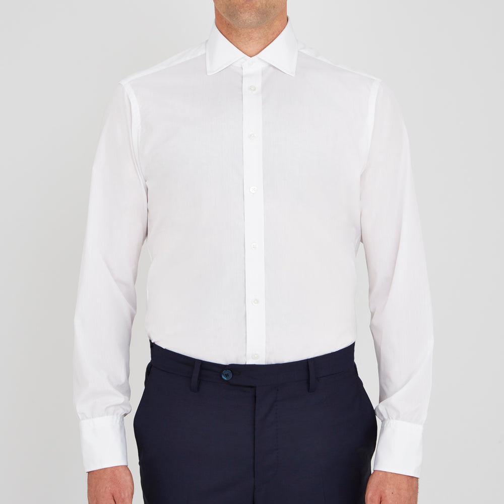A neatly folded Turnbull & Asser Two-Fold 200 White Cotton Shirt with a Regent collar and 3-button cuffs, crafted from breathable fabric, is displayed on a light grey background with the label visible inside the collar.