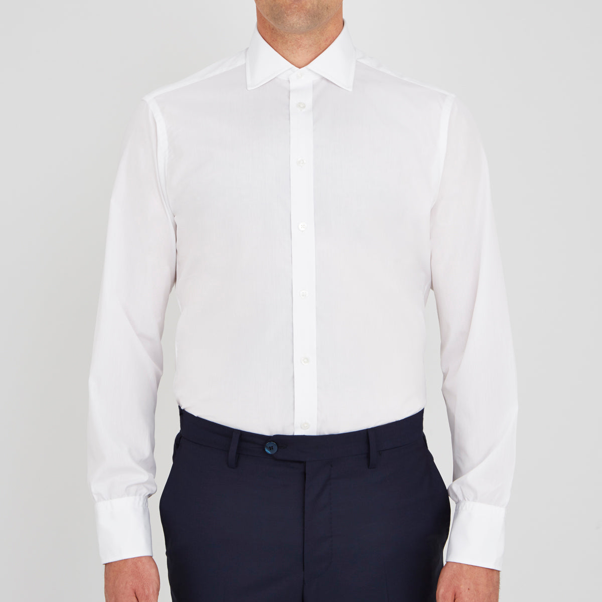 View 2 of product A neatly folded Turnbull & Asser Two-Fold 200 White Cotton Shirt with a Regent collar and 3-button cuffs, crafted from breathable fabric, is displayed on a light grey background with the label visible inside the collar.