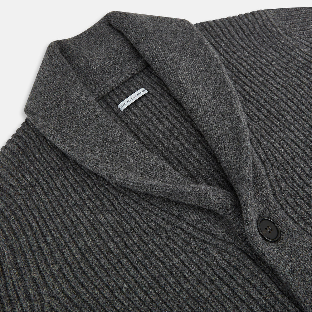 The Turnbull & Asser Shadow Grey Cashmere Shawl Collar Cardigan features ribbed detailing, a front button closure, and two front pockets, shown against a plain white background.