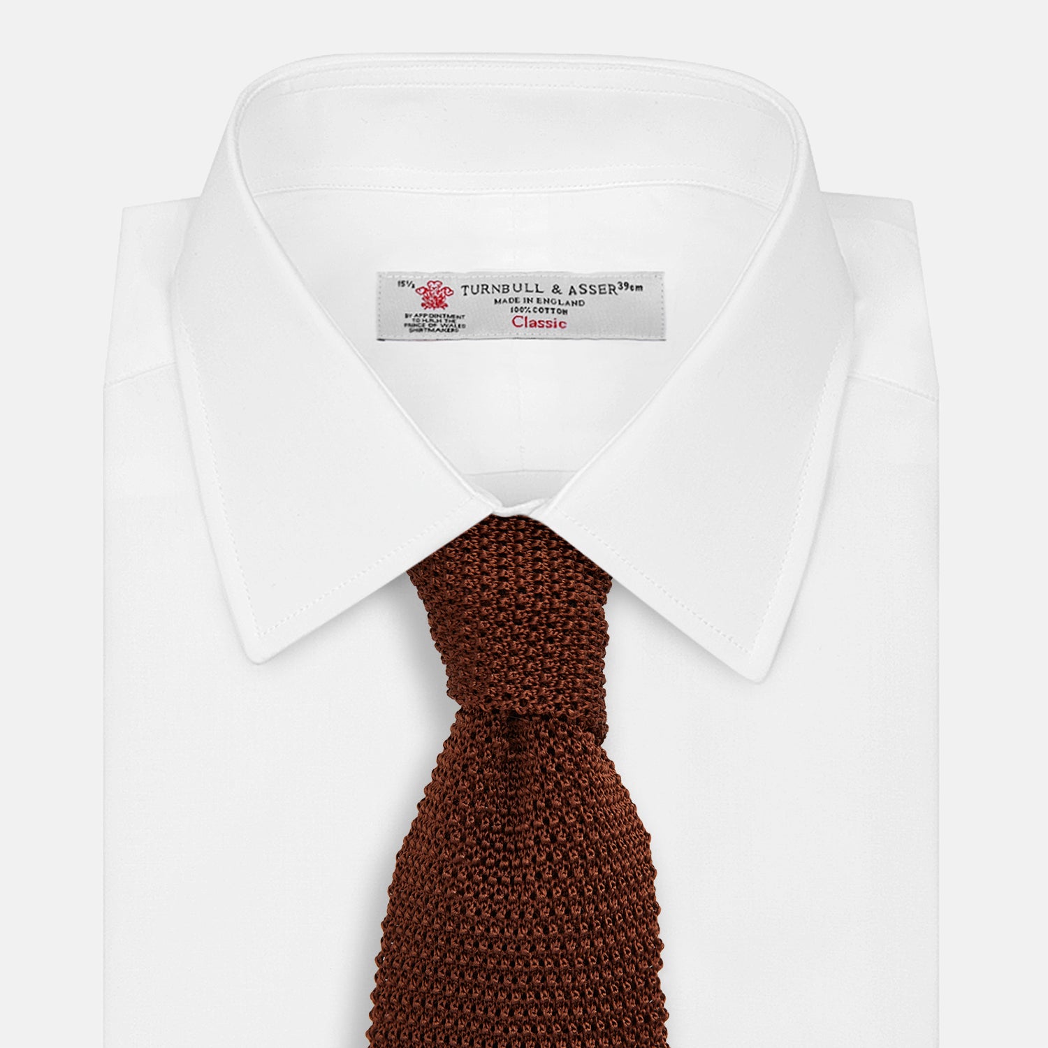 View 2 of product The Turnbull & Asser KNITTED BROWN SILK PLAIN TIE—a stylish, textured accessory—appears rolled up on a white background, perfect for elevating smart outfits.