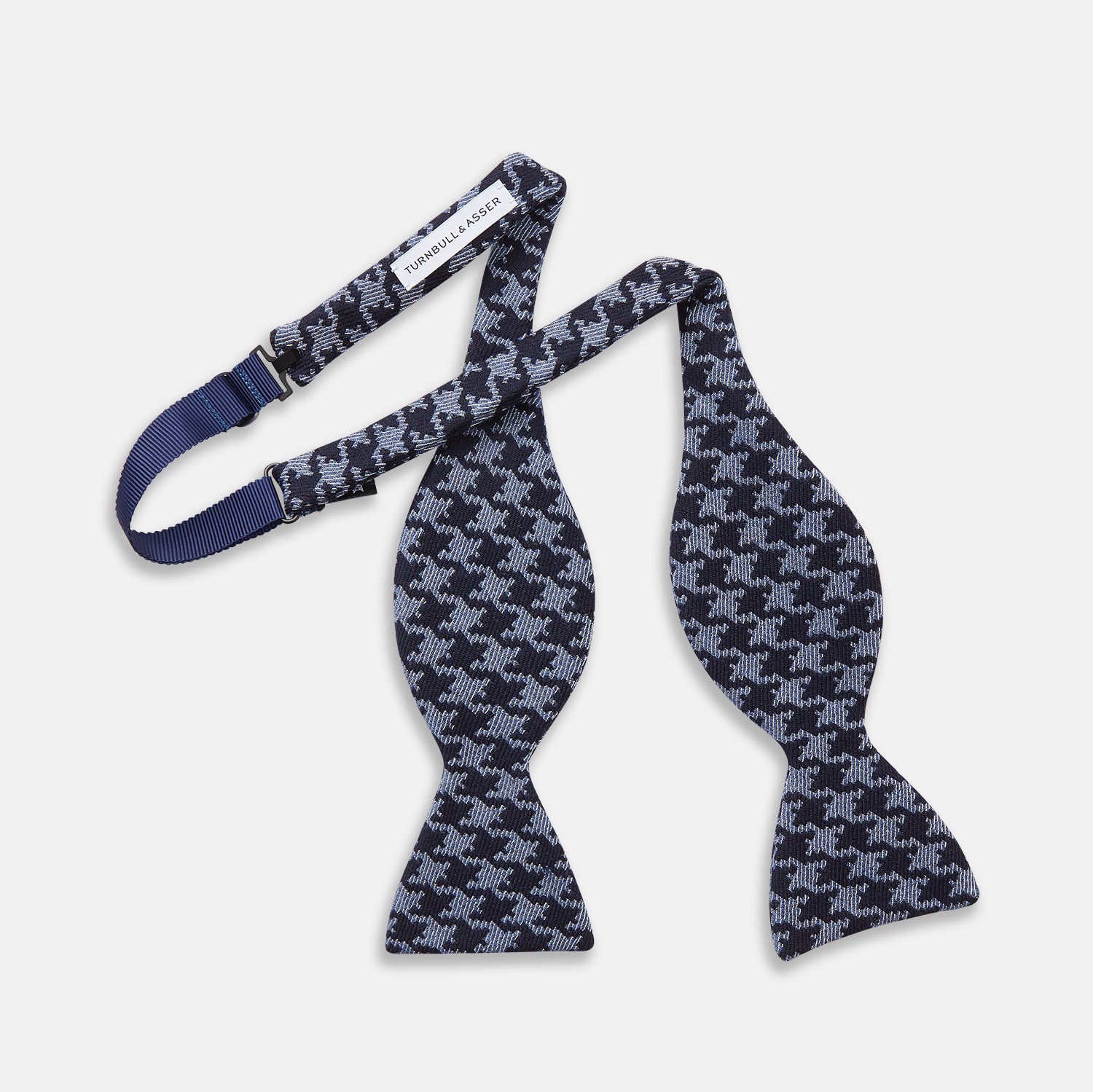 View 3 of product The Turnbull & Asser Navy and Blue Houndstooth Wool Blend Bow Tie features a self-tying design with a blue and black houndstooth pattern, showcased on a plain white background.