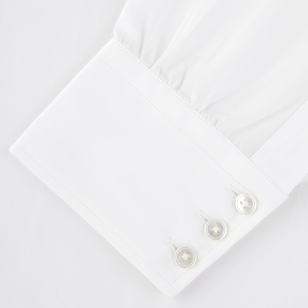 The Turnbull & Asser Two-Fold 120 White Shirt with a Regent collar and 3-button cuffs is neatly folded and displayed against a light blue background.
