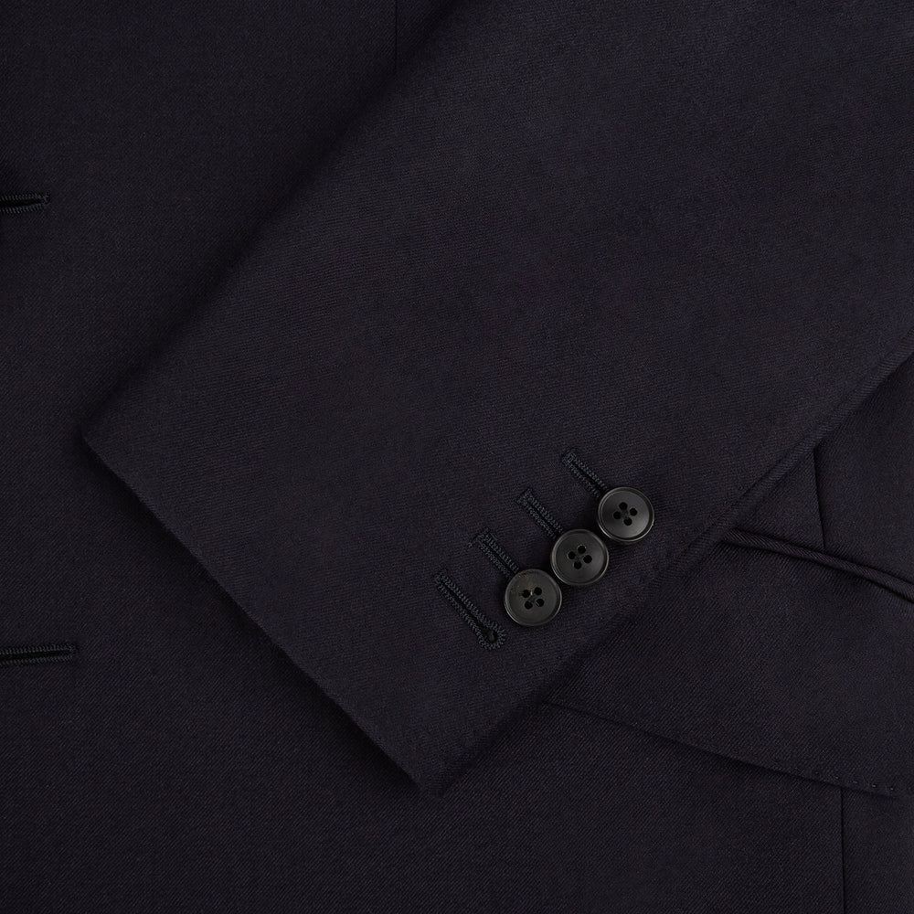The Turnbull & Asser Long Navy Single Breasted Suit, shown on a white background, features a blazer with notch lapels and matching tailored trousers—ideal for formal occasions.