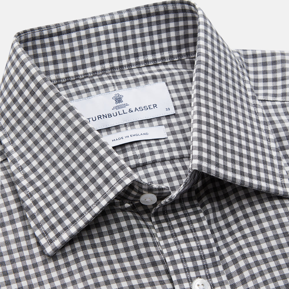 The Turnbull & Asser Grey Gingham Check Cotton Melange Regular Fit Mayfair Shirt, shown flat against a white background, offers a classic designer look with its small black and white check pattern and button-down design.