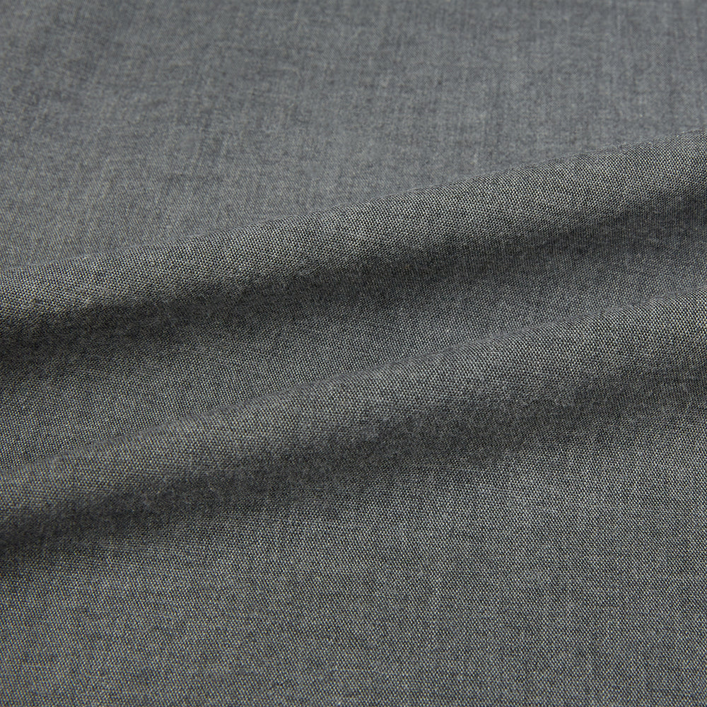 The Pale Charcoal Westminster Shirt by Turnbull & Asser features British craftsmanship with a tailored silhouette, long sleeves, pointed collar, buttoned cuffs, and a solid pale charcoal hue, elegantly shown against a white background.