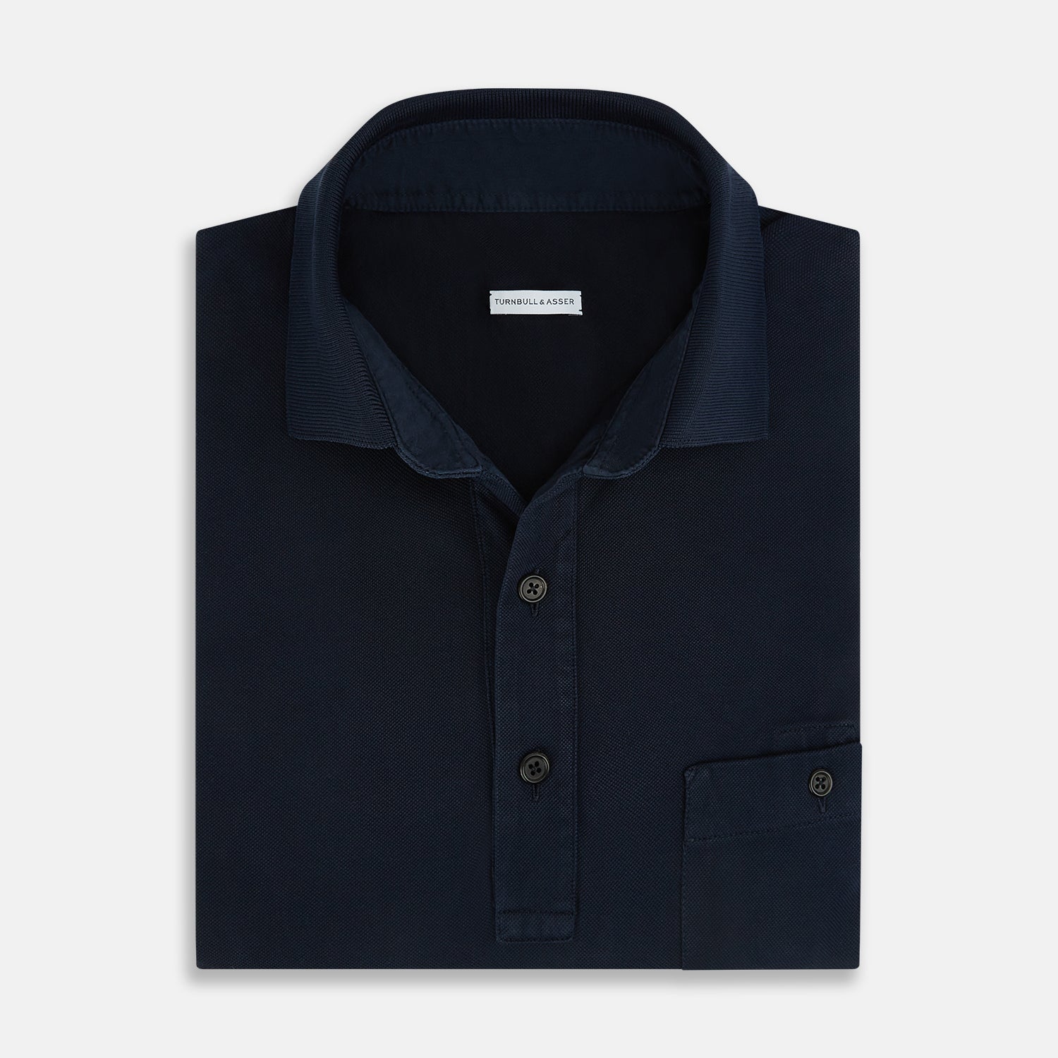 View 4 of product The Turnbull & Asser Navy Polo Shirt features short sleeves, a collar, three-button placket, and a single buttoned chest pocket, shown flat on a plain white background.