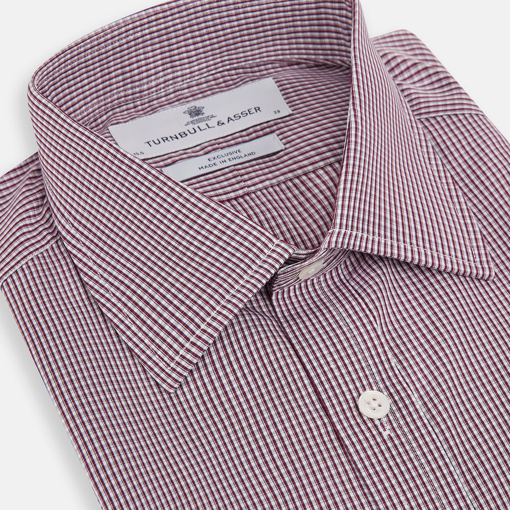 The Turnbull & Asser Burgundy Micro Check Mayfair Shirt features long sleeves, a pointed collar, and white buttons—perfect for formal wear. Shown laid flat on a white background.