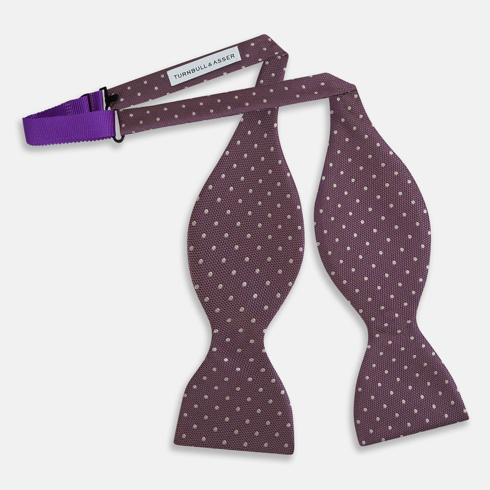 The Turnbull & Asser Lilac and Purple Micro Dot Silk Bow Tie, shown on a plain white background, features tiny white dots—a stylish accessory to enhance any men's outfit.