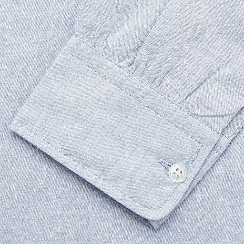 Turnbull & Asser’s Pale Blue Linen Blend Weekend Fit Unwin Shirt features long sleeves, a band collar, two chest pockets, and white buttons—ideal for casual summer wear.