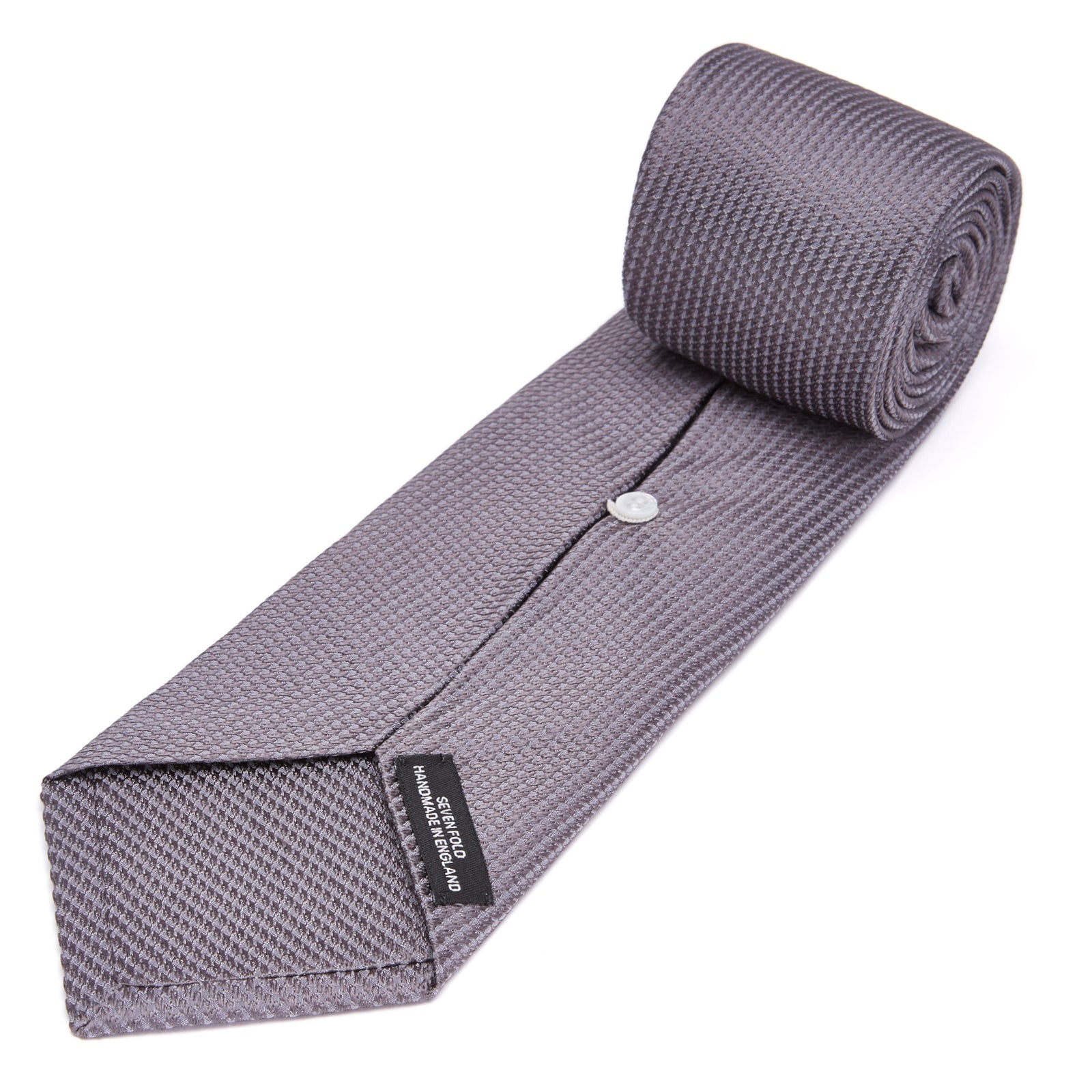 View 4 of product A close-up of the Dark Grey Plain Woven Lace Silk Tie by Turnbull & Asser, neatly rolled and textured, displayed on a light background—an elegant accessory for smart wardrobes.