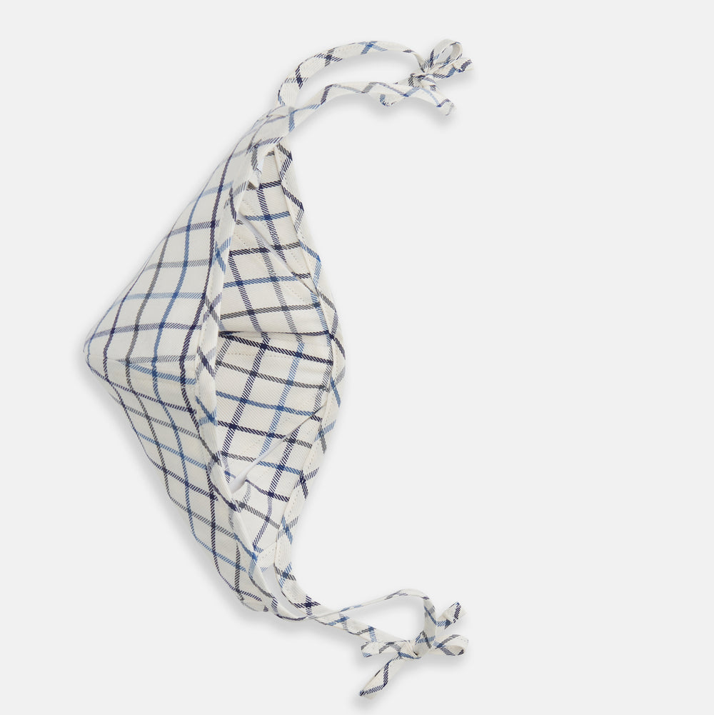 The Turnbull & Asser Check Blue Multi Commuter Mask features a blue plaid design, adjustable fabric ear loops tied in bows, and comes with 3 Viroformula™ filters. Laid flat on a white background.