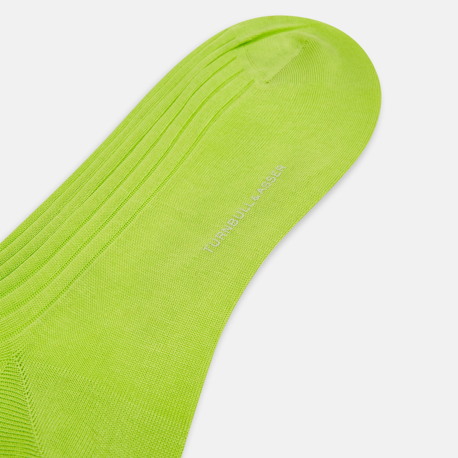 View 3 of product The Turnbull & Asser Lime Long Sock is a single bright green, knee-high sock with a ribbed texture, crafted from soft mercerised cotton, shown against a white background.