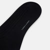 View 3 of product A single Midnight Thick Knit Mid-Length Sock by Turnbull & Asser, crafted from black mercerised Egyptian cotton, is shown in side profile against a plain white background with the toe pointing left.