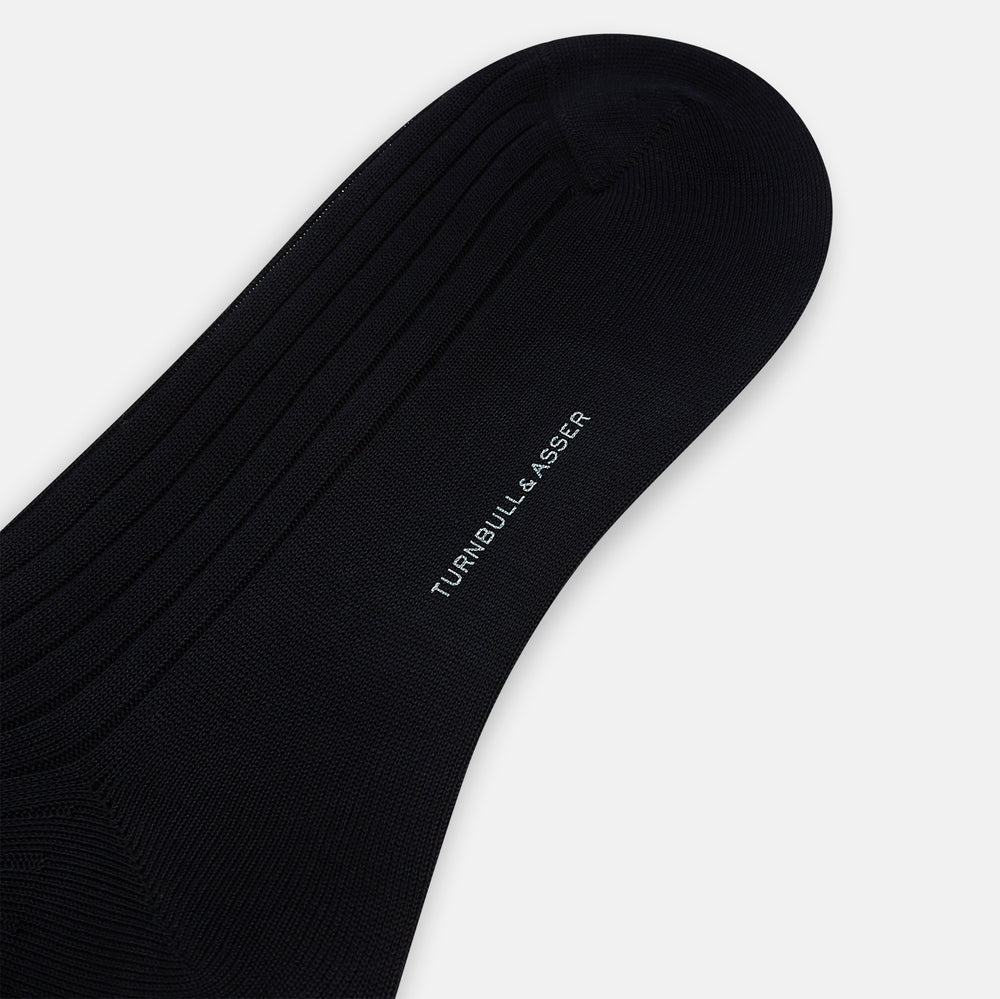 A single Midnight Thick Knit Mid-Length Sock by Turnbull & Asser, crafted from black mercerised Egyptian cotton, is shown in side profile against a plain white background with the toe pointing left.