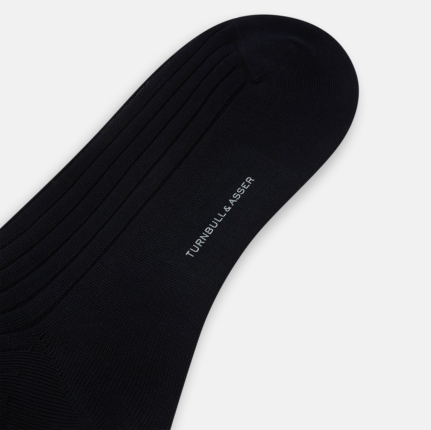 View 3 of product A single Midnight Thick Knit Mid-Length Sock by Turnbull & Asser, crafted from black mercerised Egyptian cotton, is shown in side profile against a plain white background with the toe pointing left.
