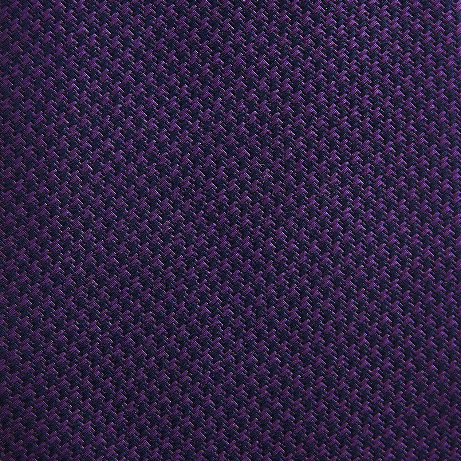 View 3 of product The HOUNDSTOOTH NAVY PLUM TIE by Turnbull & Asser, featuring a textured pattern, is showcased rolled up against a plain white background—an essential accessory.
