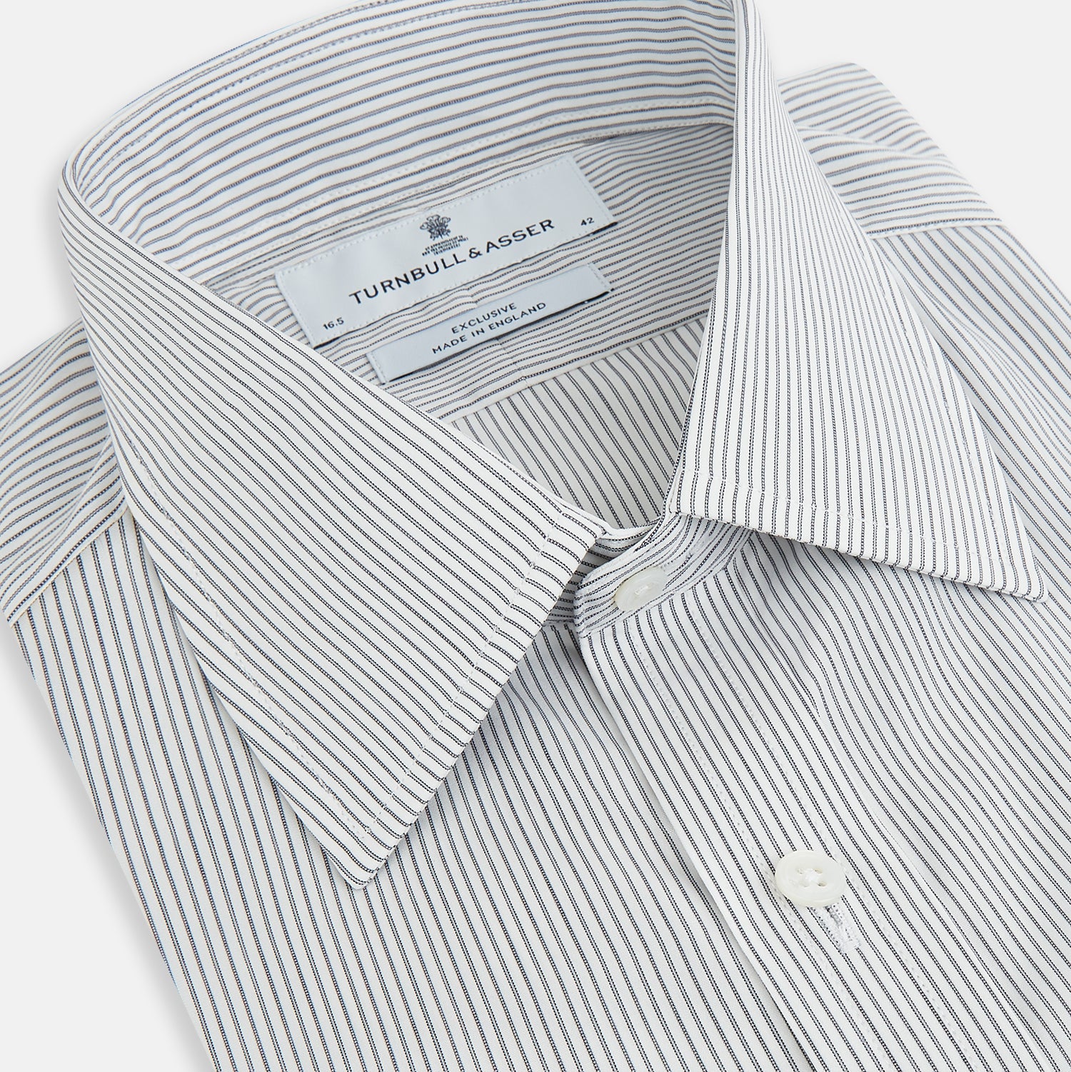 View 2 of product A long-sleeved Midnight Blue Fine Track Stripe Mayfair Shirt by Turnbull & Asser, featuring a T&A collar and white buttons, is laid neatly flat on a white background.