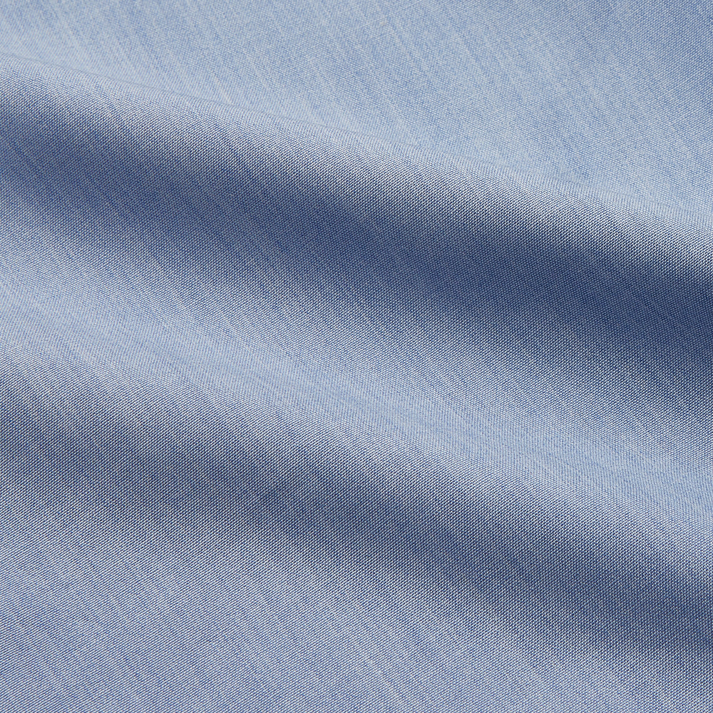 The Turnbull & Asser Slate Blue Chambray Holiday Fit Fellows Shirt features long sleeves and a classic collar, laid flat on a white background—a versatile summer piece for any occasion.