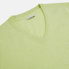 View 2 of product The Turnbull & Asser Pistachio Cashmere V-neck Jumper features long sleeves, ribbed cuffs and hem. Shown in light green against a white background, it's a classic addition to any knitwear collection.
