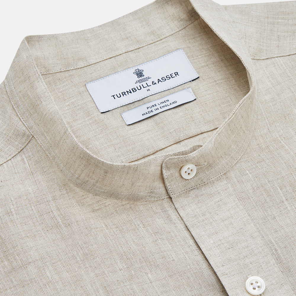 The Turnbull & Asser Light Oatmeal Linen Weekend Fit Unwin Shirt features long sleeves, a band collar, and two chest pockets—an ideal choice for effortless summer style.