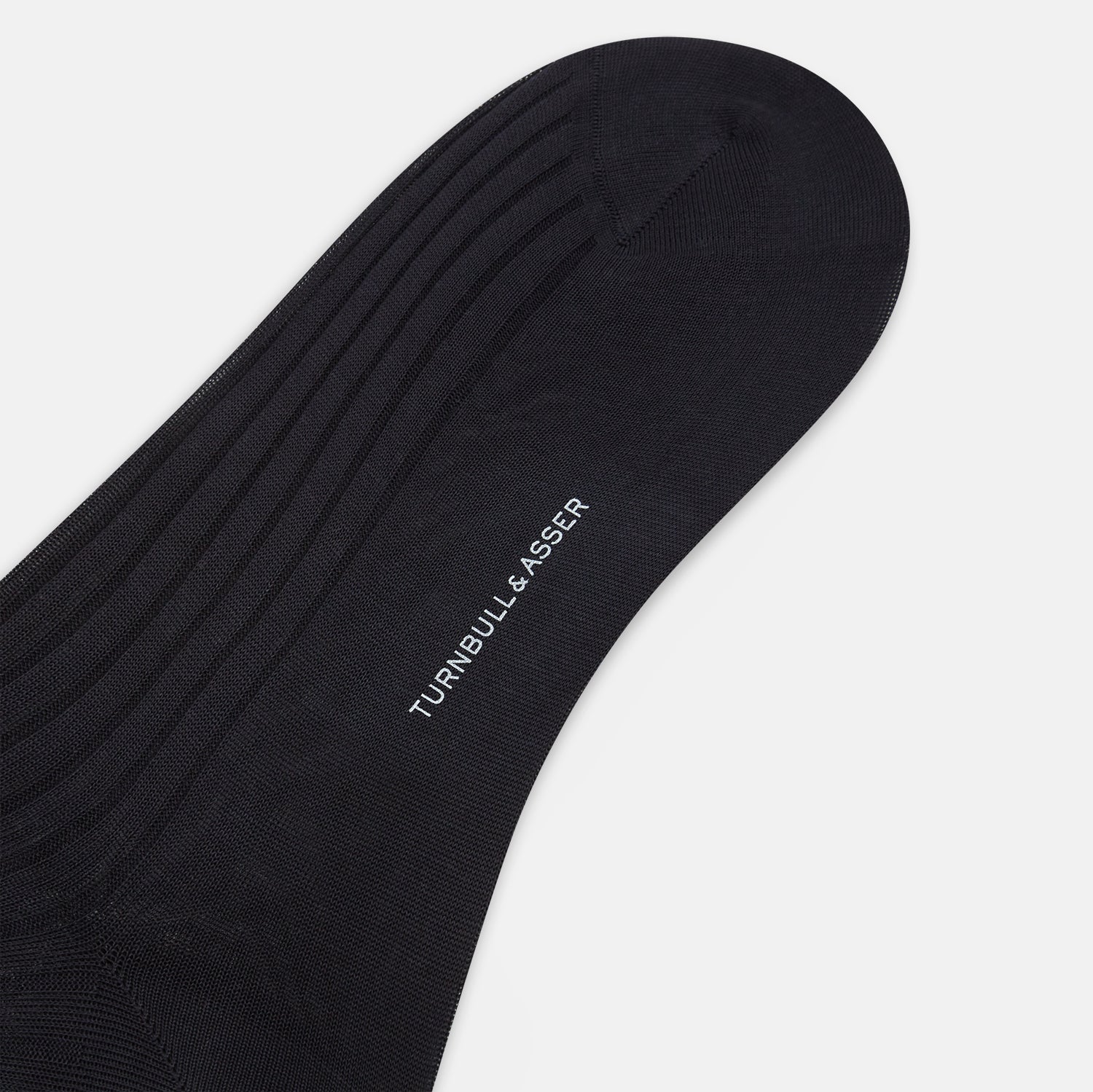 View 3 of product The Turnbull & Asser Smoke Mid-Length Sock, in black with a ribbed design, is displayed upright on a white background to highlight its refined comfort and coverage from toe to cuff.