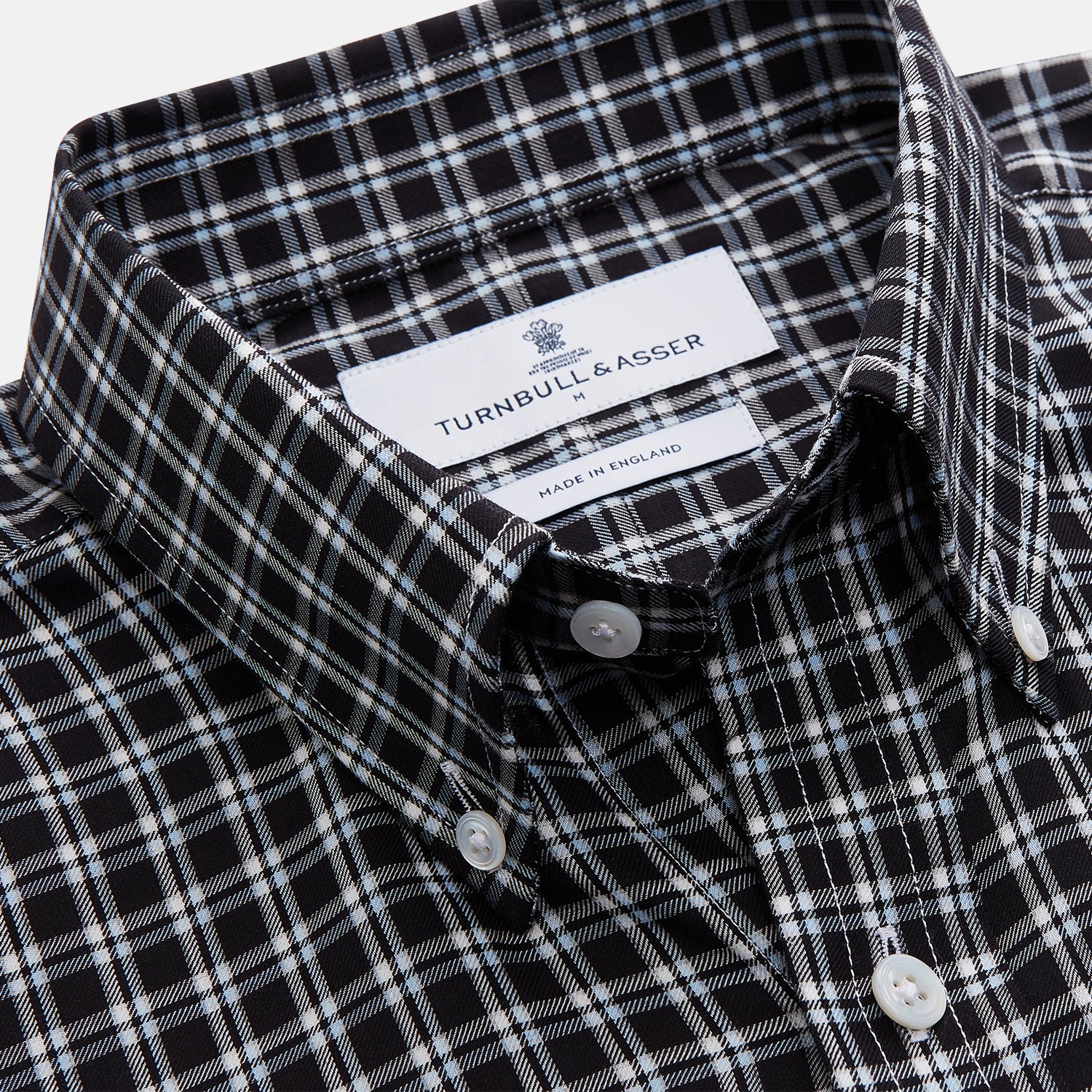 View 3 of product The Turnbull & Asser Black Multi Check Cotton Blend Weekend Fit Hayne Shirt features a Dorset button-down collar and white buttons, with a black and white plaid pattern, shown laid flat on a white background.