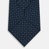 View 3 of product The Turnbull & Asser Navy Floral Silk Tie is crafted from fine English silk, featuring a repeating pattern of small white circular floral motifs, and is neatly rolled for display against a plain white background.