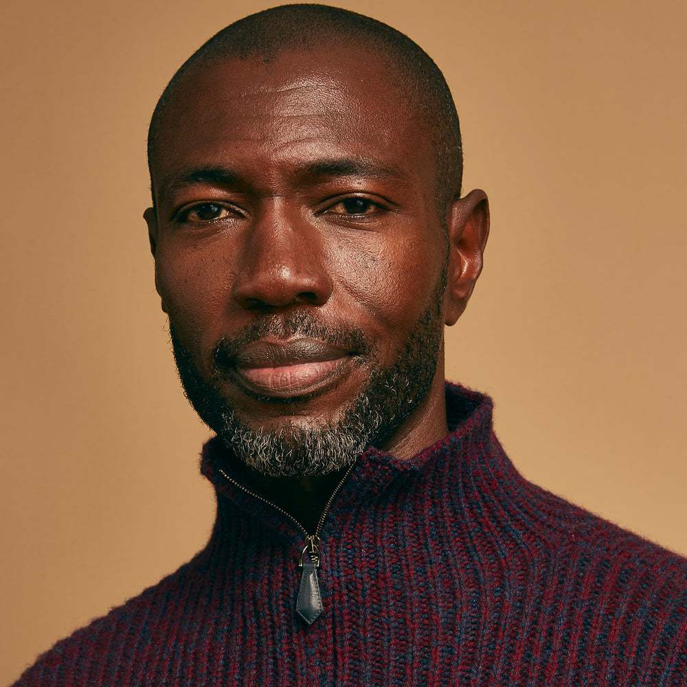 The Turnbull & Asser Burgundy Mullion Half Zip Rib Cashmere Jumper features a high collar and half-zip front in dark red and navy cashmere, shown laid flat on a white background—ideal for an elevated casual look.