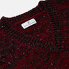 View 2 of product The Turnbull & Asser Russet Red Melange Wool Hafod Cricket Jumper features maroon and black speckles, a V-neck, long sleeves, and ribbed cuffs and hem, displayed flat on a white background.