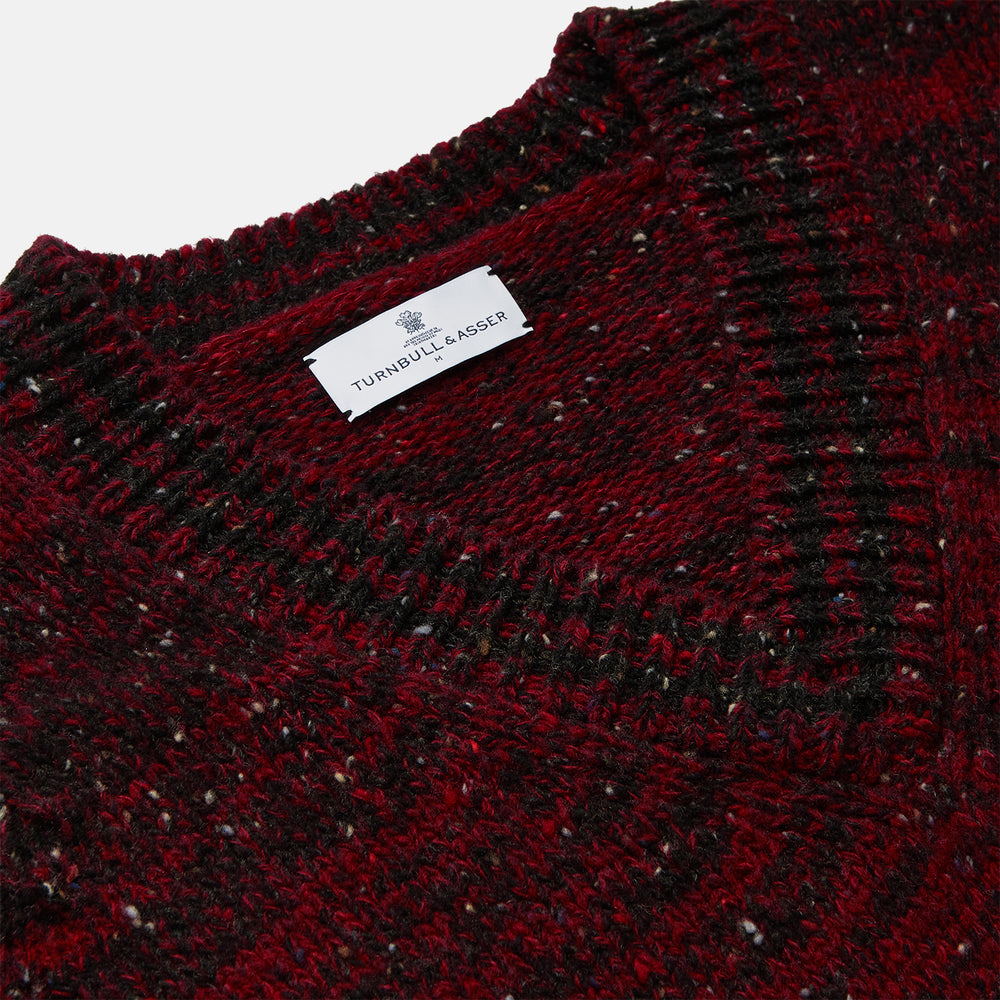 The Turnbull & Asser Russet Red Melange Wool Hafod Cricket Jumper features maroon and black speckles, a V-neck, long sleeves, and ribbed cuffs and hem, displayed flat on a white background.
