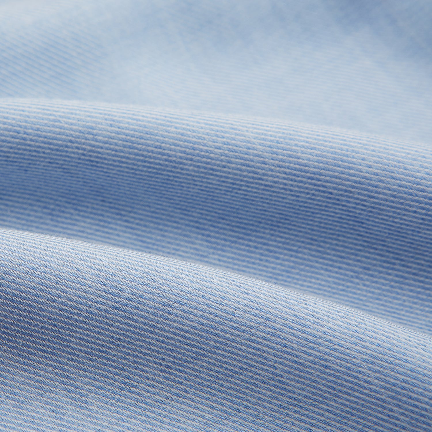 View 5 of product The Turnbull & Asser Pale Blue Cotton Cashmere Derby Collar Richmond Shirt features a soft cotton-cashmere blend, derby collar, white buttons, left chest pocket, and buttoned cuffs, shown laid flat on a white background.