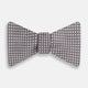 The Turnbull & Asser Grey and White Diamond Silk Bow Tie showcases a subtle diamond pattern, ideal for formalwear, and is elegantly displayed against a plain white background.