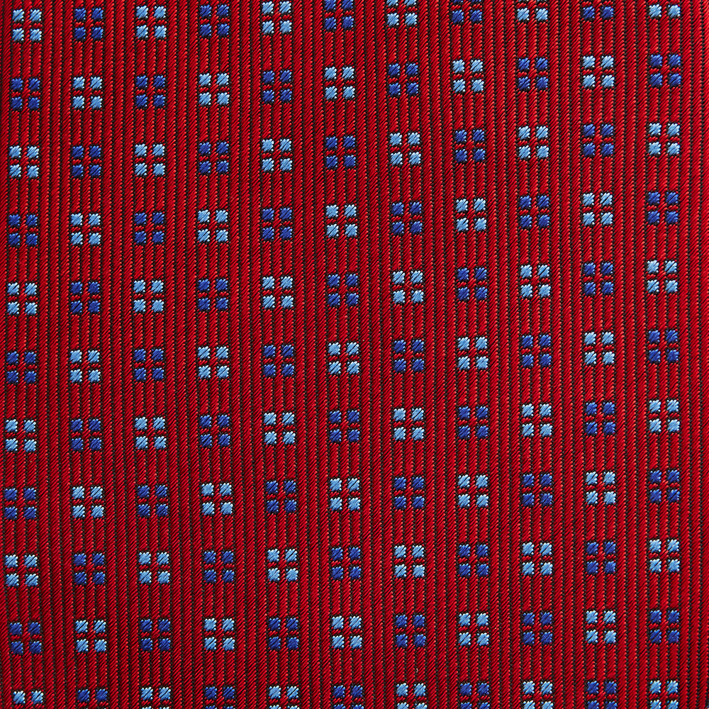 The Turnbull & Asser MINI SQUARE SPOT TULIP RED BLUE TIE features a vivid red base with blue and white geometric spots, making it a stylish addition to any refined ensemble.