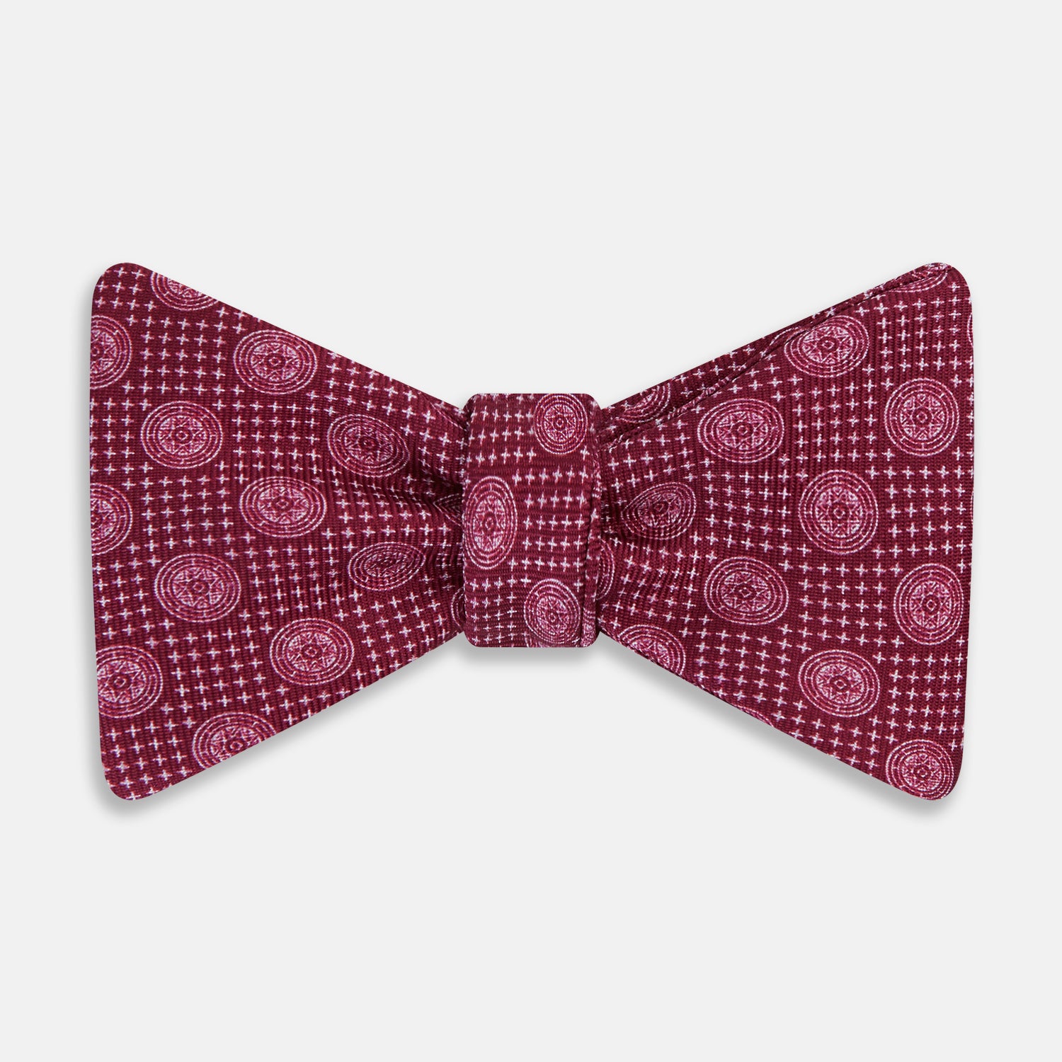 View 1 of product The Turnbull & Asser Burgundy Medallion Silk Bow Tie, featuring small white circles and crosshatch lines, is displayed on a plain white background—perfect for adding sophistication to smart attire.