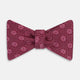 The Turnbull & Asser Burgundy Medallion Silk Bow Tie, featuring small white circles and crosshatch lines, is displayed on a plain white background—perfect for adding sophistication to smart attire.