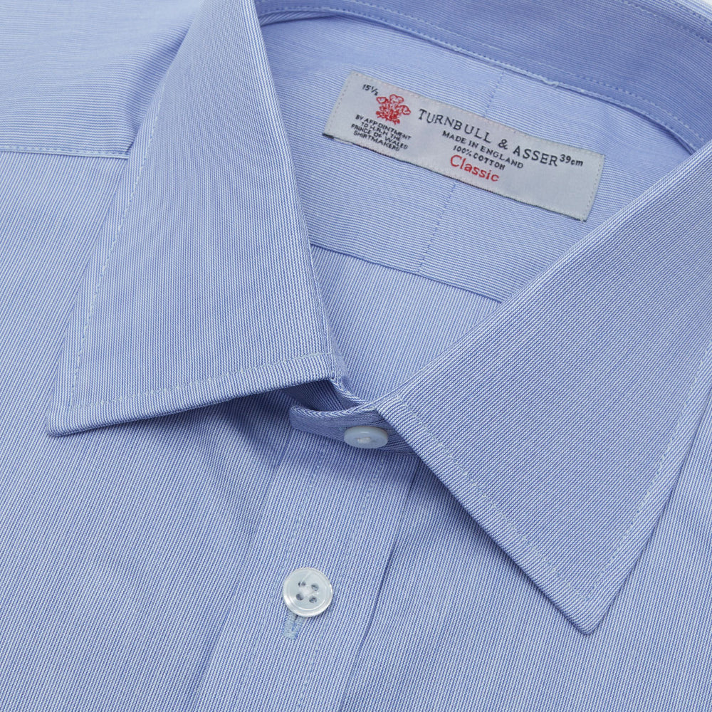 The Turnbull & Asser Blue Hairline Stripe Shirt features a T&A collar, 3-button cuffs, and subtle stripes, displayed neatly folded against a plain white background.