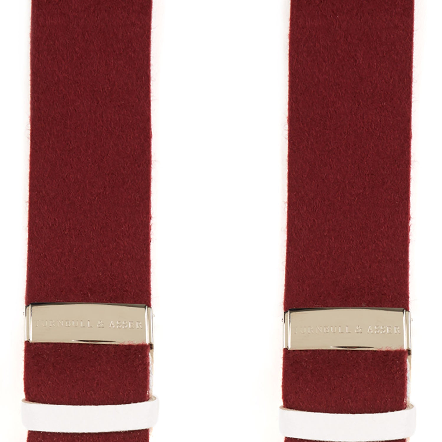 View 5 of product A pair of Turnbull & Asser Bordeaux Adjustable Felt Braces, featuring white leather ends and gold metal adjusters, made in England, are displayed vertically on a plain white background.